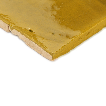 Ladrilhos de terracota verde, brilhantes e reflexivos, se encaixam perfeitamente, criando um padrão geométrico contínuo em uma s