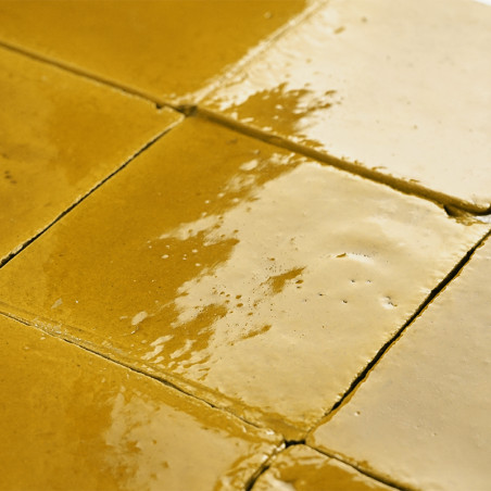 Ladrilhos de terracota esmaltados dispostos em padrão diagonal, refletindo a luz, criando uma aparência aconchegante e texturiza