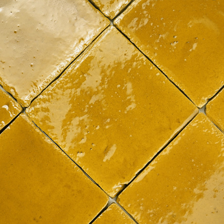 Geglazuurde terracottategels gerangschikt in een diagonaal patroon, reflecterend licht en creëren een warm, gestructureerd uiter
