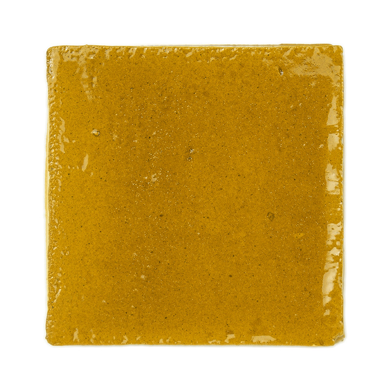 Ladrilhos de terracota amarelos brilhantes dispostos em uma grade elegante de três por três contra um fundo branco liso.