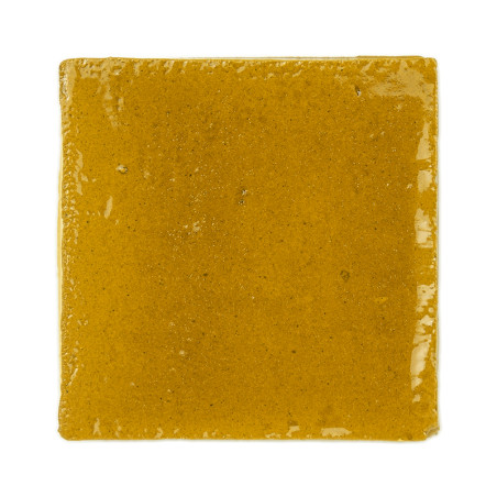 Ladrilhos de terracota amarelos brilhantes dispostos em uma grade elegante de três por três contra um fundo branco liso.