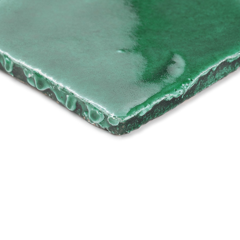 Azulejos de terracota de color verde brillante, en ángulo con luz natural, enfatizando sus bordes suaves y curvos y su superfici