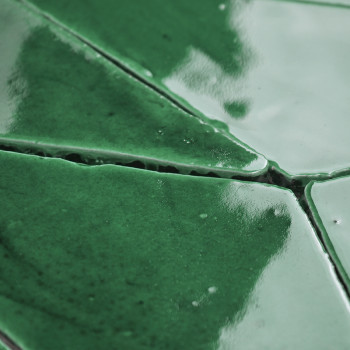 Les carreaux de terre cuite verte, brillants et réfléchissants, s'emboîtent étroitement, créant un motif géométrique sans coutur