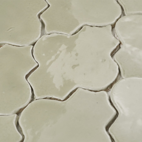 Vaso de vidro com folhas secas assenta sobre uma superfície branca, rodeado por cestos trançados, apoiados por azulejos decorati