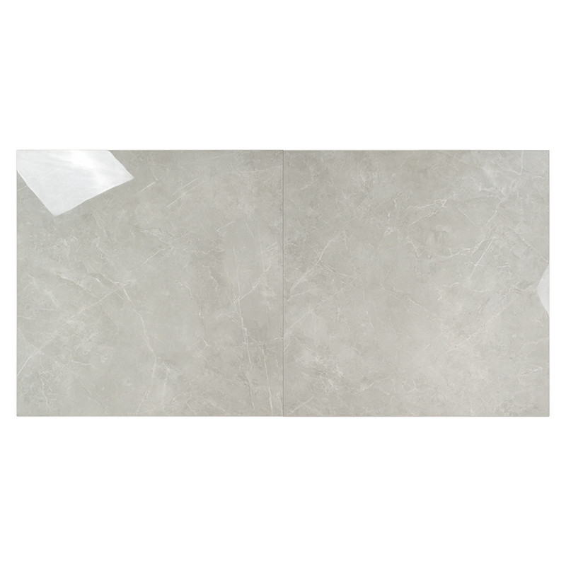 Un azulejo cerámico cuadrado de color gris claro con sutiles vetas blancas que imita la textura del mármol, creando un acabado r
