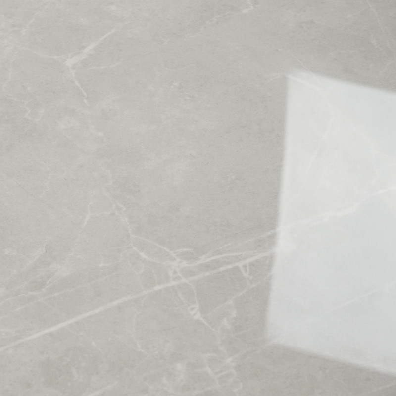 A smooth, light gray marble tile displays white, vein-like patterns crisscrossing its surface. A faint reflection of a square li