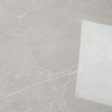 Una losa de mármol suave de color gris claro muestra patrones blancos en forma de vetas que cruzan su superficie. En el lado der