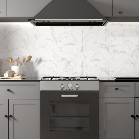 Une cuisine moderne comprend une cuisinière noire avec une hotte métallique suspendue. Des armoires grises entourent le poêle, c