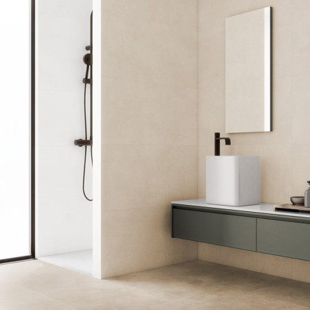 Een moderne badkamer is voorzien van een strakke, aan de muur gemonteerde donkere wastafel tegen crèmekleurige tegels, met een a