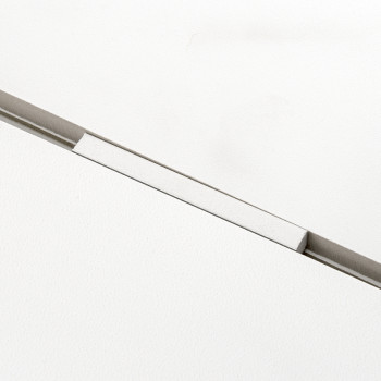 A rectangular white tile rests with a visible separator creating a thin gap, contrasting against a smooth, uniform white backgro