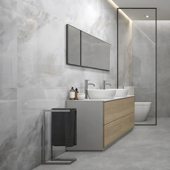 Un tocador de baño con dos lavabos y un mueble de madera se apoya contra una pared de mármol, debajo de un espejo largo en un am