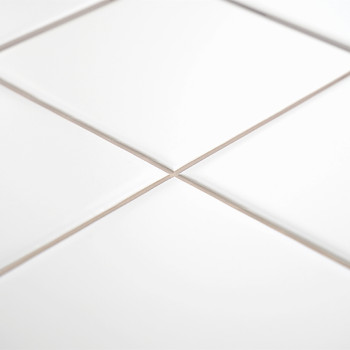Los azulejos de cerámica blanca con acabado brillante forman un patrón de cuadrícula, unidos por finas líneas de lechada, en un 