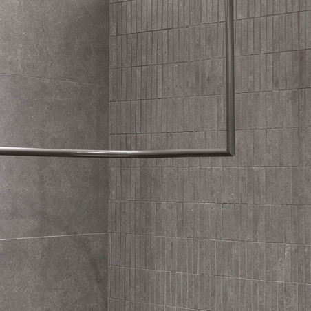 Grijze rechthoekige tegels, uitgelijnd in een rasterpatroon, vormen een hoekwand. Geen zichtbare voeglijnen, waardoor een strakk