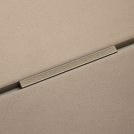 Beigefarbene rechteckige Fliesen werden durch einen dünnen Metallstreifen getrennt, der sie trennt, und sorgen so für einen naht