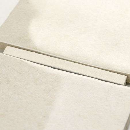 Een beige, rechthoekige tegel rust bovenop een stapel soortgelijke tegels, waardoor een netjes, ordelijk patroon ontstaat in een Een beige, rechthoekige tegel rust bovenop een stapel soortgelijke tegels, waardoor een netjes, ordelijk patroon ontstaat in een