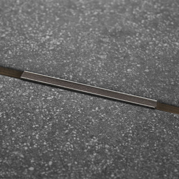 Eine dunkelgraue, gesprenkelte Fliese verfügt über einen dünnen Metallstreifen, der diagonal über die Mitte verläuft und ein mod