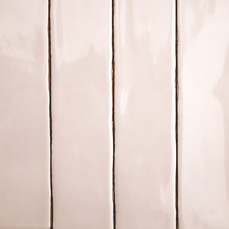 Cuatro azulejos rectangulares de color beige brillante alineados verticalmente con líneas finas y oscuras de lechada los separan