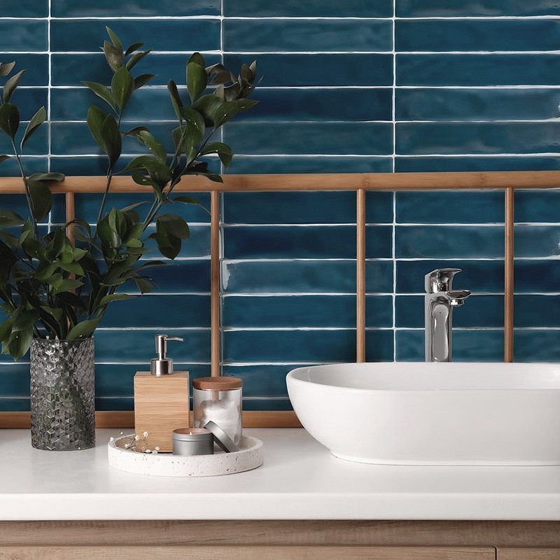 Das Waschbecken aus Keramik steht auf einer weißen Badezimmerablage neben einer Topfpflanze und einem Toilettentablett, mit blau