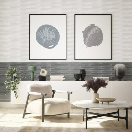 Ein modernes Wohnzimmer verfügt über einen cremefarbenen Stuhl vor einem runden Couchtisch mit getrockneten Pflanzen vor einem H