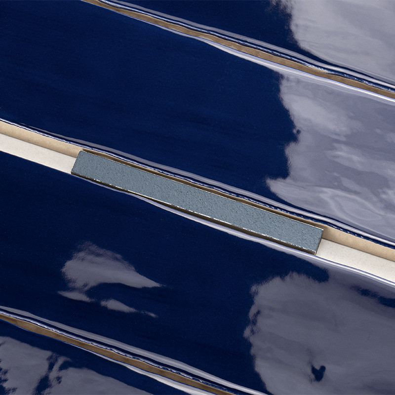 A glossy, dark blue tile reflects clouds in the sky, with a central horizontal strip of light grey, providing contrast.