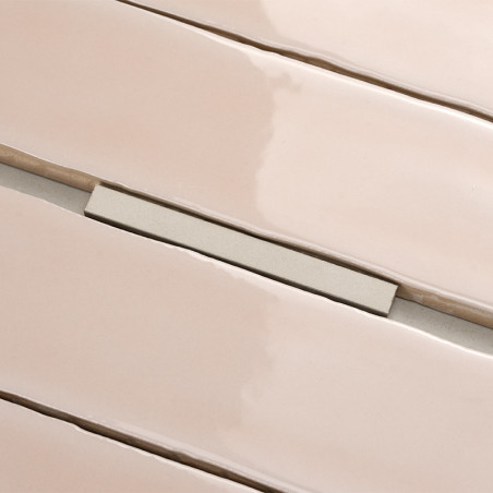 Rechteckige, glänzende beige Fliesen, leicht versetzt, liegen nebeneinander auf einer ebenen Fläche. Dazwischen ist ein schmaler Rechteckige, glänzende beige Fliesen, leicht versetzt, liegen nebeneinander auf einer ebenen Fläche. Dazwischen ist ein schmaler