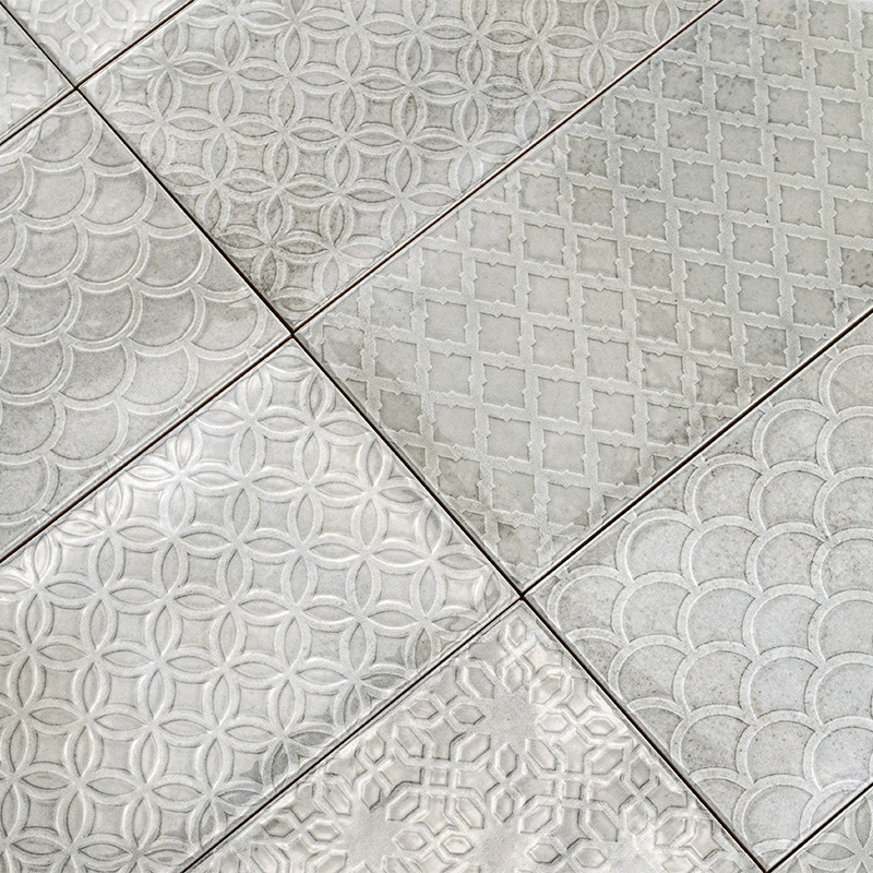 El patrón de mosaico presenta seis rectángulos, cada uno de ellos grabado con diseños geométricos como círculos y diamantes, cre
