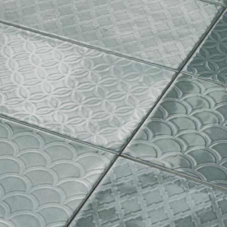 Rectangular tiles display varied raised patterns—circles, scales, and grid-like designs—in a glossy, light teal material, giving