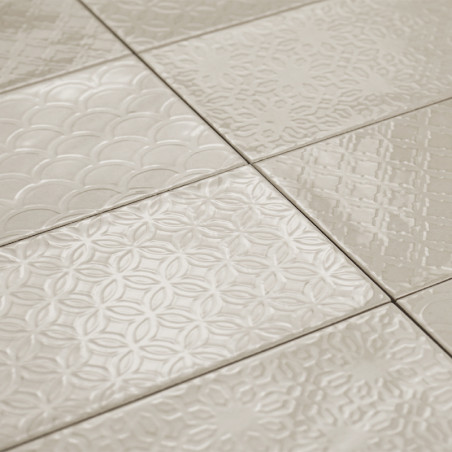 Keramikfliesen weisen verschiedene geprägte geometrische Muster auf, wodurch eine strukturierte Oberfläche in einem neutralen Be