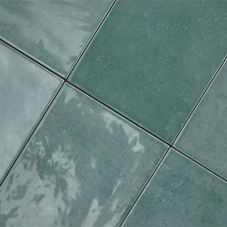 Grüne Keramikfliesen sind in einem Gittermuster angeordnet, reflektieren das Licht und weisen subtile Farbvariationen auf, wodur