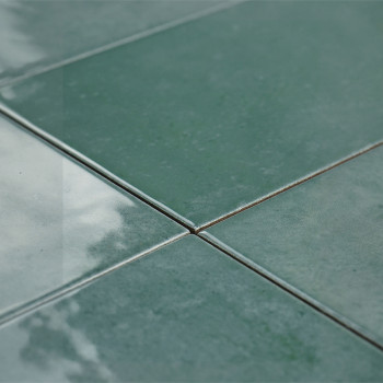 In der Mitte treffen sich vier glänzend grüne Fliesen, die das Licht reflektieren und so im Innenbereich eine glatte, polierte O