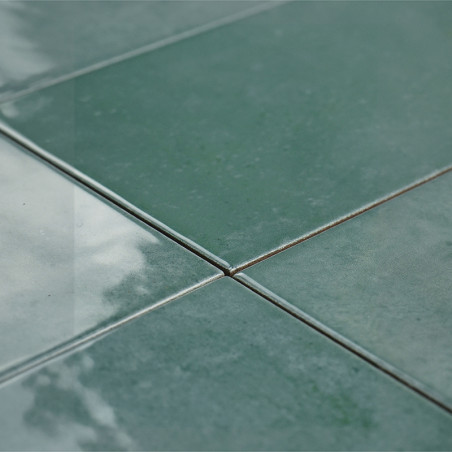 In der Mitte treffen sich vier glänzend grüne Fliesen, die das Licht reflektieren und so im Innenbereich eine glatte, polierte O