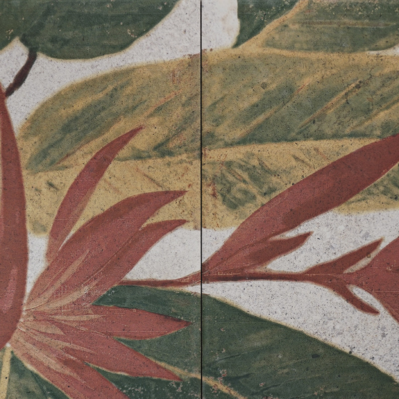 Dos azulejos adyacentes muestran hojas abstractas de color naranja y verde superpuestas sobre un fondo beige moteado, creando un