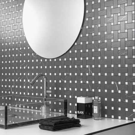 Een reflecterende ronde spiegel hangt boven een tegelwand met geometrisch patroon, met in elkaar grijpende zwarte tegels met wit Een reflecterende ronde spiegel hangt boven een tegelwand met geometrisch patroon, met in elkaar grijpende zwarte tegels met wit
