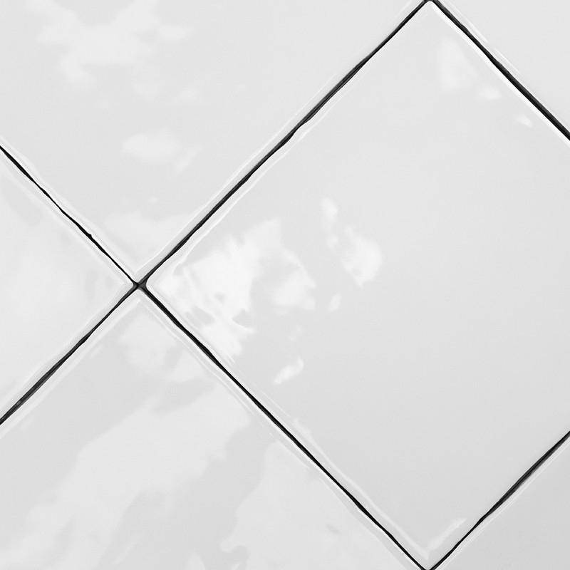 Weiße Keramikfliesen bilden ein diagonales Muster mit glatten Oberflächen, die das Licht reflektieren, eingerahmt von dünnen sch