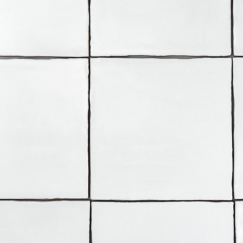 White square tiles arranged in a grid pattern, separated by thin, dark grout lines, form a minimalist wall surface.