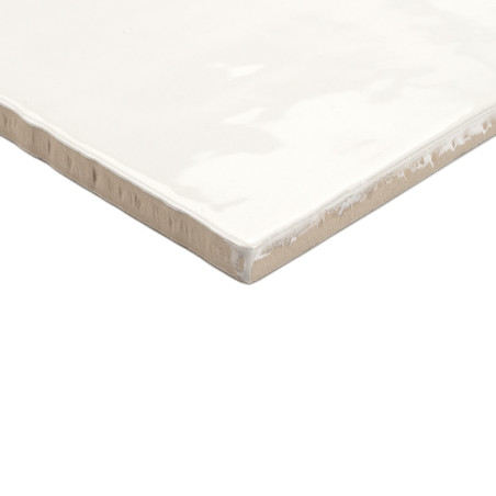 Een vierkante keramische tegel heeft een glanzende, witte afwerking met licht ruwe beige randen, rustend op een effen witte acht