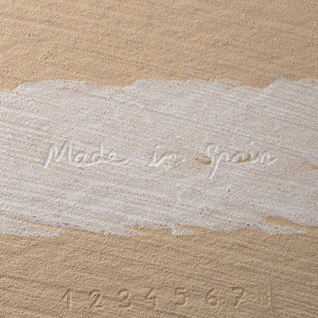 De tegel heeft de tekst `Made in Spain` en de cijfers `1 2 3 4 5 6 7` in reliëf op een beige gestructureerd oppervlak.
