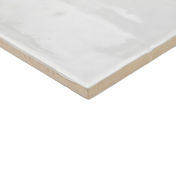 Um revestimento cerâmico brilhante e esbranquiçado fica plano, exibindo uma superfície lisa com variações sutis de textura. suas