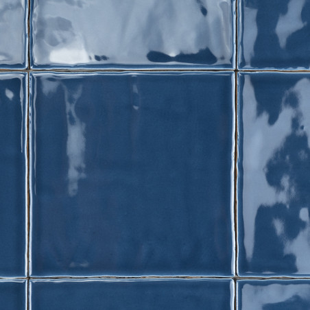 Blaue Keramikfliesen reflektieren das Licht und bilden ein glänzendes Gittermuster. Die Oberflächenstruktur erzeugt Glanzlichter Blaue Keramikfliesen reflektieren das Licht und bilden ein glänzendes Gittermuster. Die Oberflächenstruktur erzeugt Glanzlichter