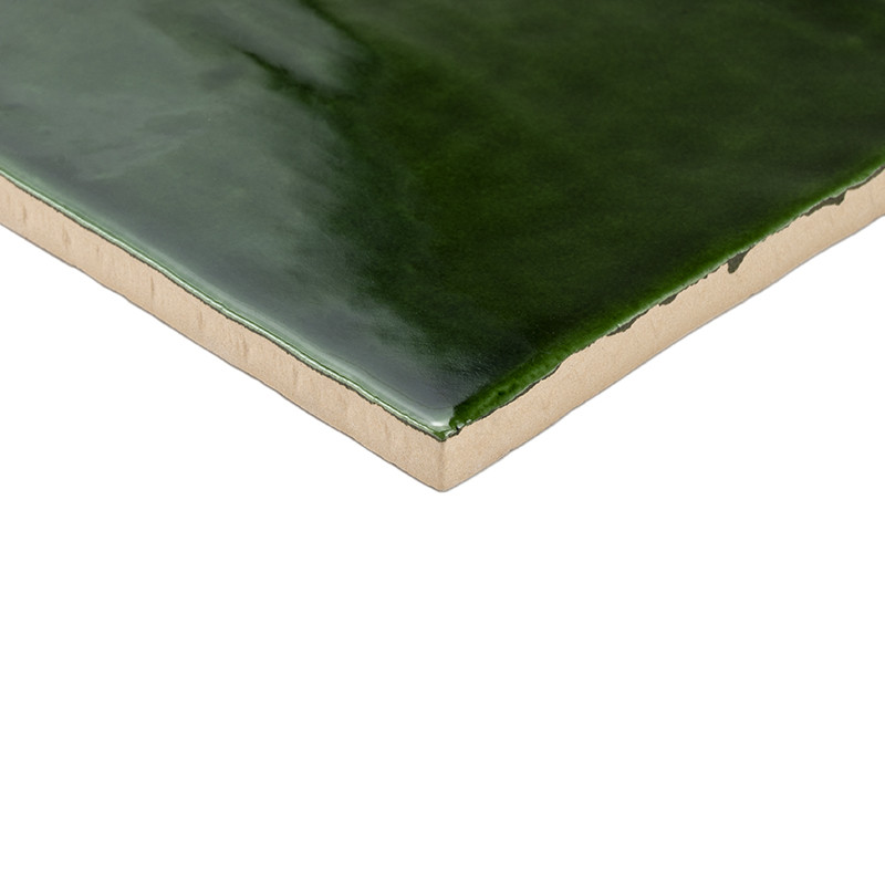 Um revestimento cerâmico verde escuro brilhante é mostrado com uma superfície lisa e bordas bege, contra um fundo branco liso.