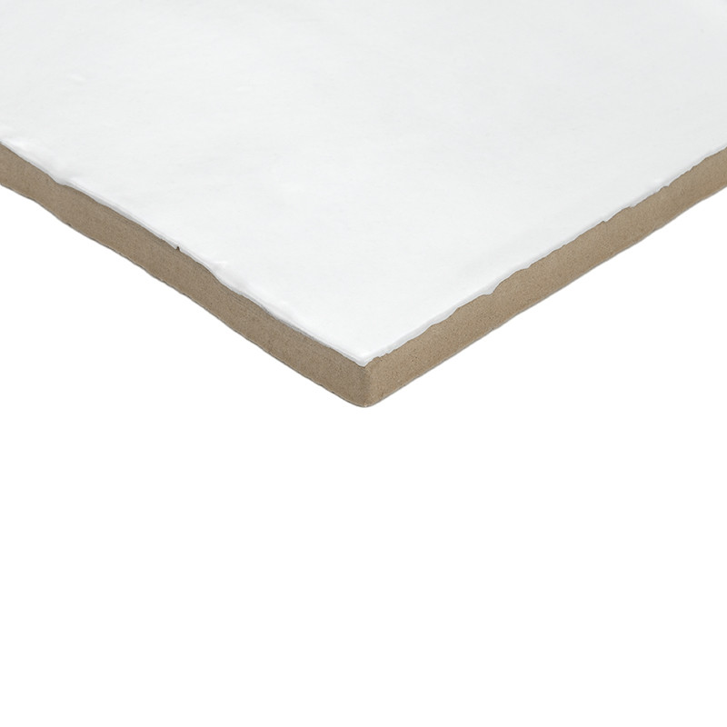 A white, square ceramic tile with smooth edges rests on a plain, light brown background, showcasing its clean, minimalist design