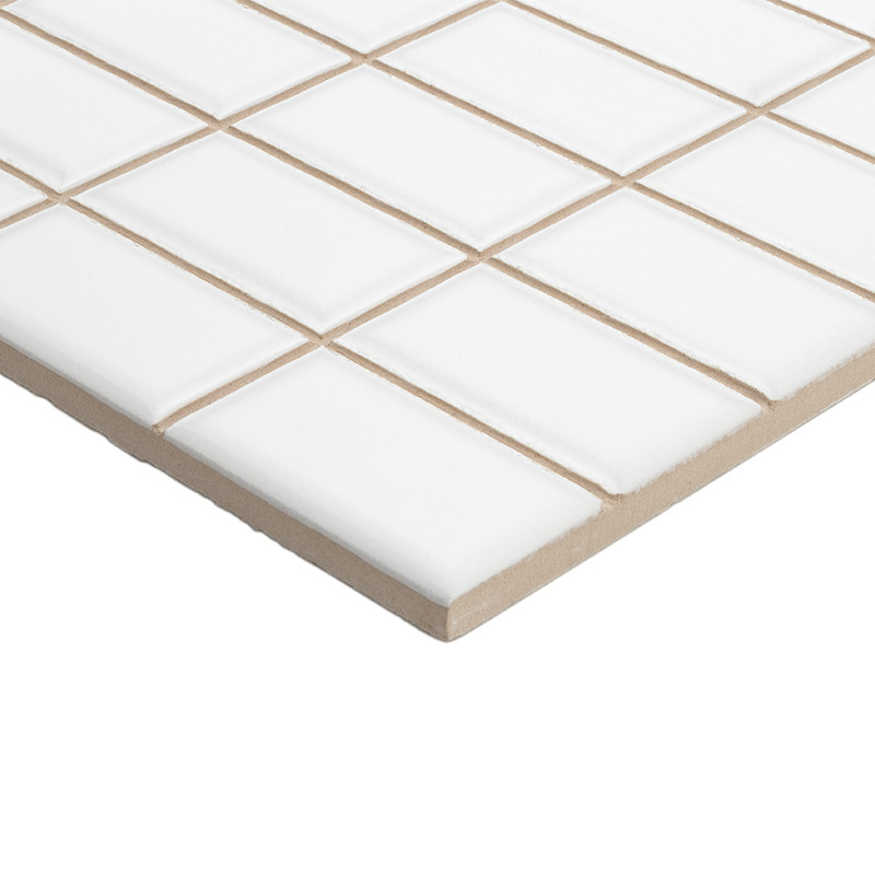 Les carreaux de céramique blanche, disposés en quadrillage, reposent sur une base beige, créant une surface lisse et uniforme.