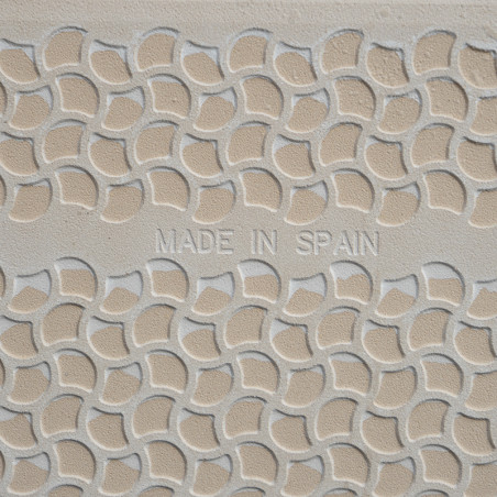 Keramische tegels met reliëf hebben een repetitief gebogen schubbenpatroon. de woorden `MADE IN SPAIN` staan ​​centraal in het o