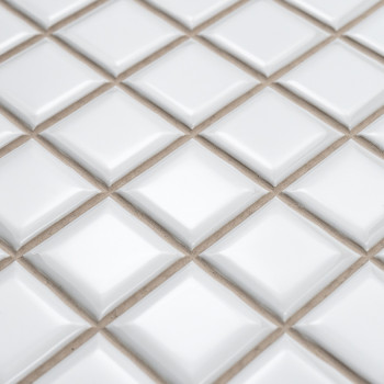 Carreaux de céramique carrés disposés en losanges avec des surfaces surélevées, créant un effet texturé et tridimensionnel sur u