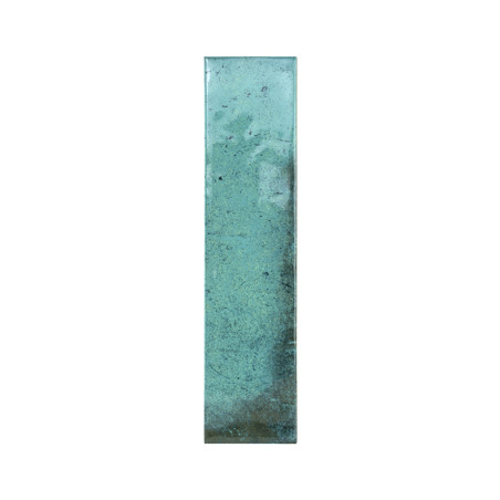 Le carreau rectangulaire sarcelle présente un motif texturé et patiné. Sa surface présente de subtiles variations de couleur, cr