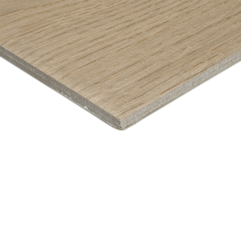 Un azulejo cerámico cuadrado de color beige con una sutil textura de vetas de madera se apoya sobre un fondo blanco liso, resalt
