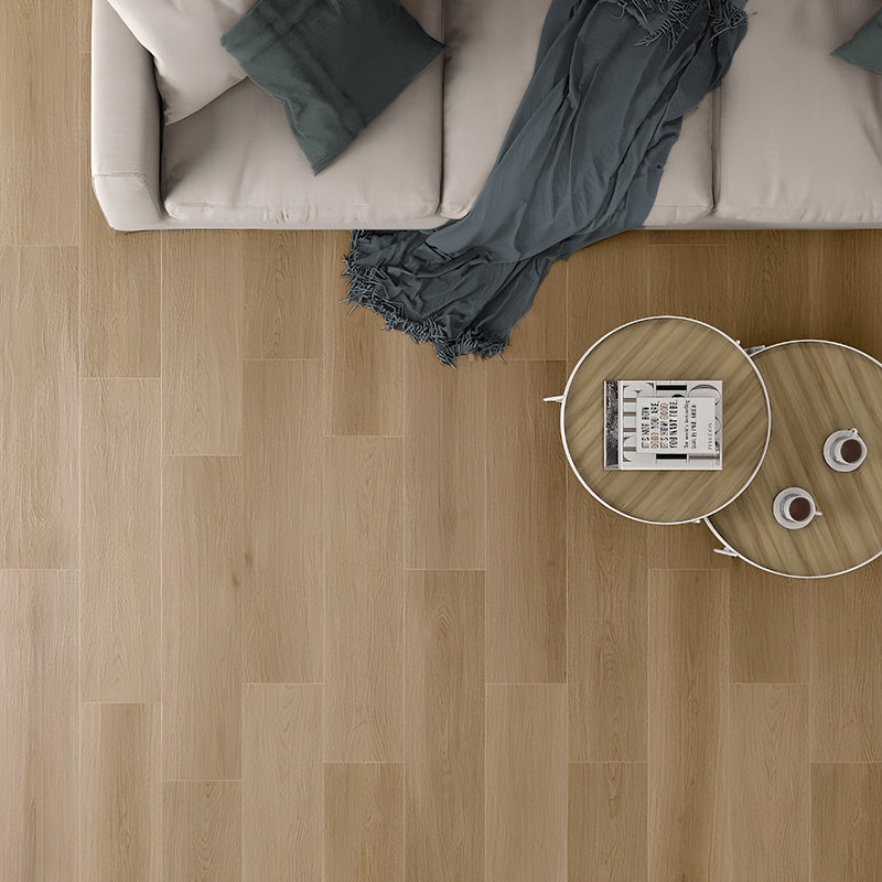 Un canapé beige avec des coussins bleu sarcelle se trouve à côté d'une table basse en bois sur un parquet en bois clair, créant 