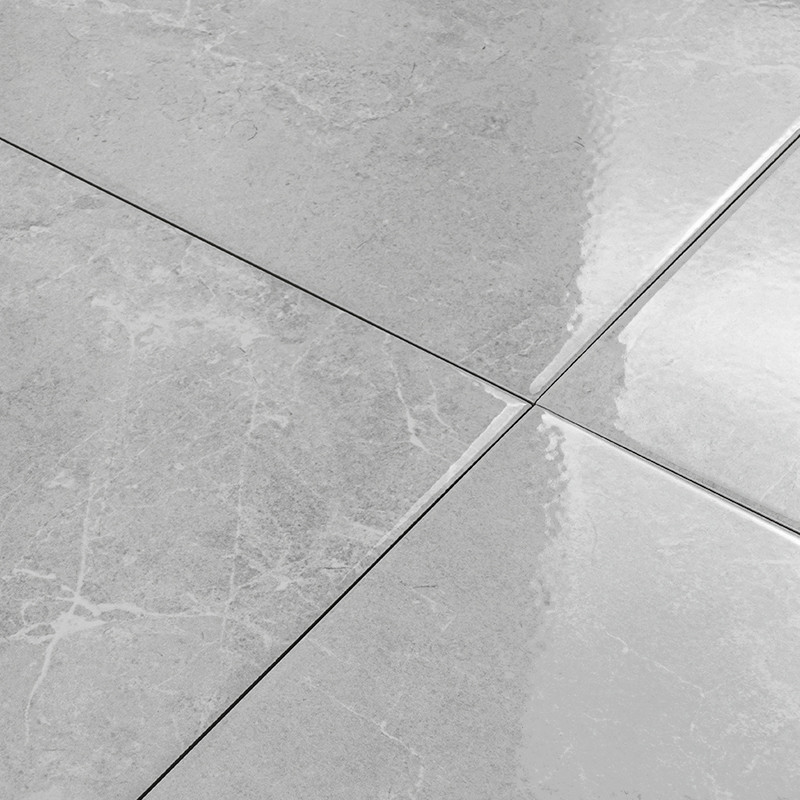 Four grey, glossy ceramic tiles form a smooth, intersecting grid, reflecting light and revealing subtle marbled textures across 