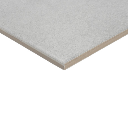 Azulejo cuadrado, liso de color gris claro con un borde biselado, colocado sobre un fondo blanco, enfatizando su superficie limp