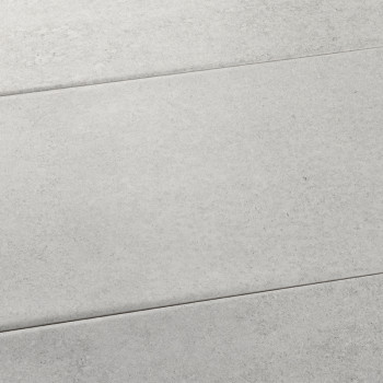 Le carrelage rectangulaire gris est plat, affichant une texture subtile et mouchetée. Il s’inscrit dans un agencement de surface